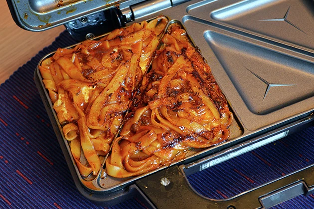 (3)こんがり! チーズの上から残った冷凍ボロネーゼをのせ、ホットサンドメーカーを強引に閉じて、いつもより時間をかけてじっくり焼き上げよう。表面にしっかりと焦げ目がついたら完成