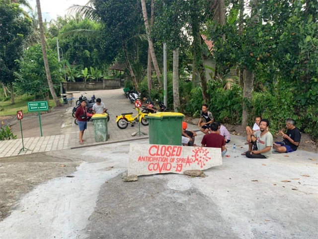 観光スポットの入り口。看板を立て座り込む地元民たち（写真／ソラ）