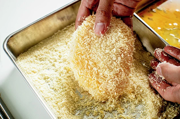 (2)まぶす! 塩コショウを振って下味をつけたら、溶き卵を絡めてからパン粉をたっぷりとまぶそう。中身が見えなくなるようにパン粉をつけることで一段ととんかつだと思い込みやすくなる
