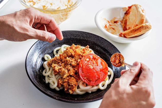 (3)盛る! 温めたうどんを食器に盛り、モスチーズバーガーを潰したミートソースをかけて取り除いたトマトを添えれば完成。バンズは余ったソースをつけて食べればフードロスゼロ!