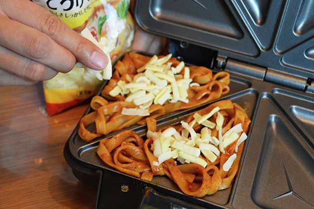 (2)チーズ! ボロネーゼの上にとろけるチーズをのせる。量はお好みで加減していいが、多すぎると溶けてあふれてしまうので要注意。ほぐしたハンバーグやポテトチップスを足してもよい