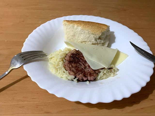 旅人の夕飯。レオンがくれたハンバーグと米。パンとチーズは私物です