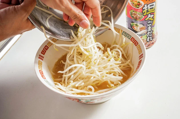 (2)モヤシ! 鍋にお湯を沸かし、モヤシをサッと湯通しする。時間はお好みの硬さに合わせて調整しよう。モヤシから水分が出るので、ザルでしっかりお湯をきってからスープに入れよう