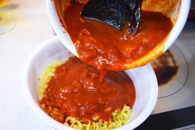 (3)かける! トマトがグツグツと煮立ったら辛辛魚のかやく入りスープと液体スープを混ぜ、麺をカップに戻したらスープをかける。仕上げに後入れ粉末スープをかけたら完成!