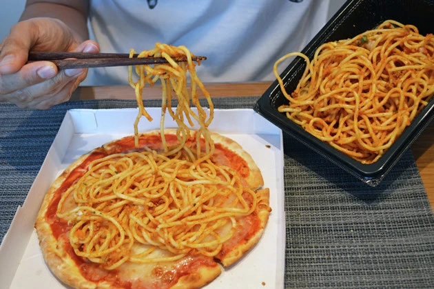 (1)パスタ! ミートソースボロニア風スパゲッティをよく混ぜてソースをしっかりと絡めたら、マルゲリータピザの上から全体に広げるようにしてのせる。量はお好みで調整しよう