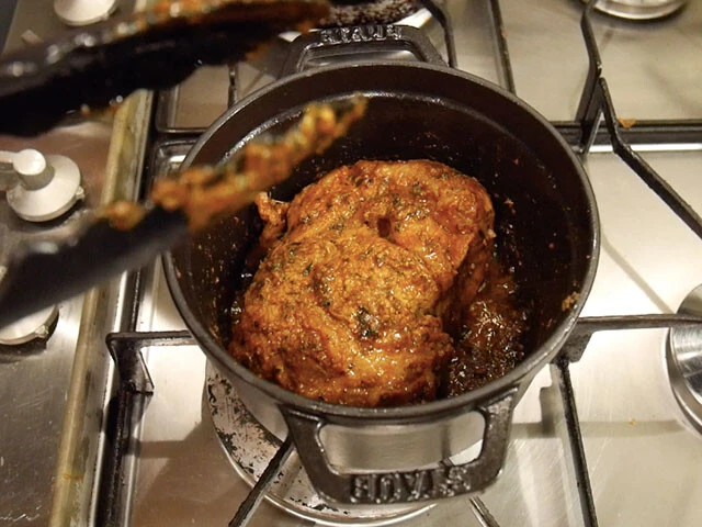 １．鍋に油（分量外）をひき、スパイスで下味を付けた肉の表面を中弱火で焼く。