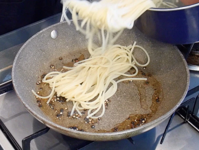 ７．パスタを表示時間より３分前にあげてフライパンに投入し、ゆで汁をおたま１杯入れて麺に吸わせていくように和えながらゆでる。（水分がなくなったらゆで汁を追加）