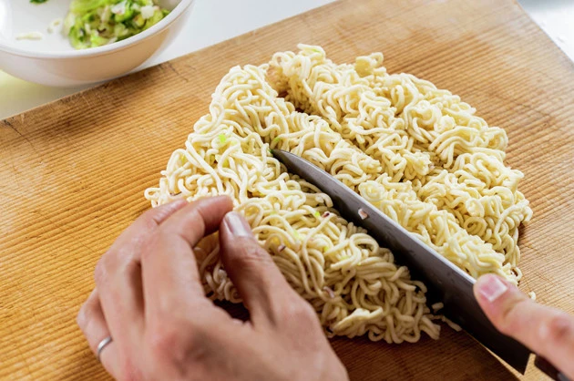 （１）切る！　いか焼そばに熱湯を注いで３分待ち、湯ぎりをしたら麺をまな板の上に移して包丁で１～２ｃｍ程度にカットしよう。かやくは麺と一緒にお湯で戻しても、別皿で戻してもＯＫ