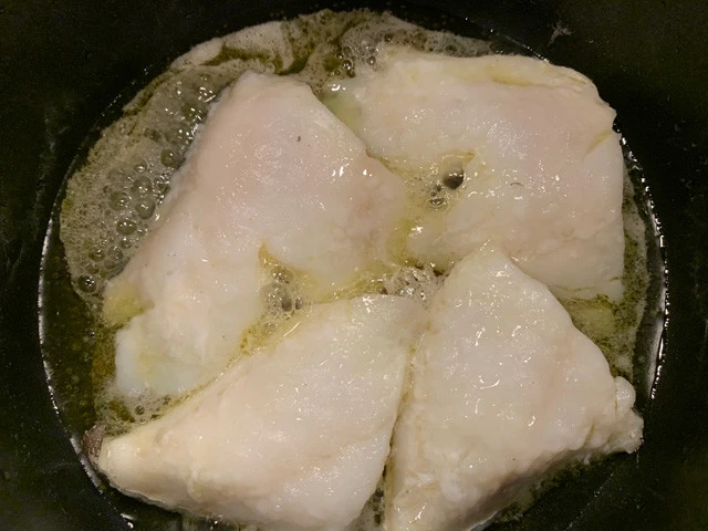 極弱火でゆっくりタラを温める。２、３分程度で白い泡（タラのゼラチン質）がプクプクと出てくるので、オリーブオイルと混ぜるように時々鍋を揺すりながら１０～１５分