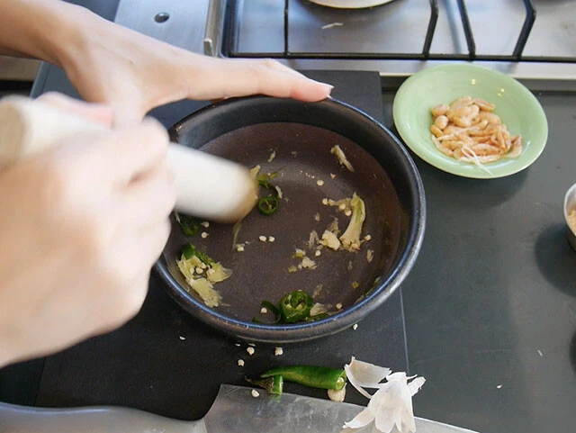 ２．ボウルや鉢に、皮をむいたニンニクと生唐辛子を入れて潰す。（画像よりも大きいボウルのほうが作りやすいです）