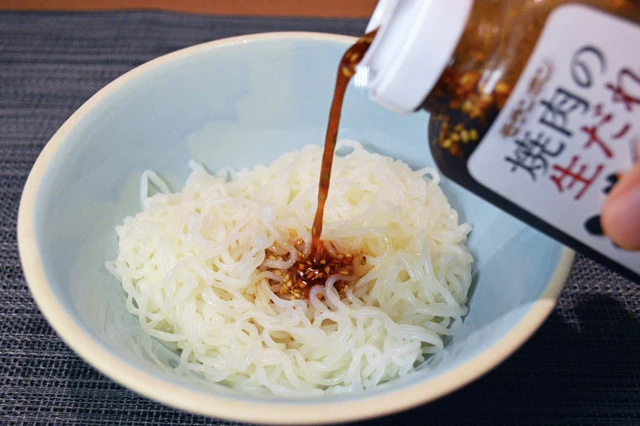 (1)タレ! とうふ麺の水気をきったら丼に移してレンチンし、焼き肉のタレを回し入れる。時間の経過とともに麺から水分が出て味が薄まるので、タレは割と多めに入れても問題ない