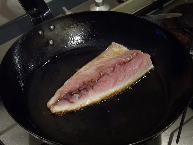 ８．フライパンに油を入れ、さばを流水で洗いキッチンペーパーでふいたら、皮面から中弱火で３分ほど焼く。