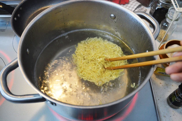 (2)ゆでる! もうひとつの鍋でたっぷりのお湯を沸かし、辛辛魚の容器から麺だけを取り出して4分ゆでよう。ここではかやくを入れないので間違えないこと。ゆで終えたら麺をザルにあける