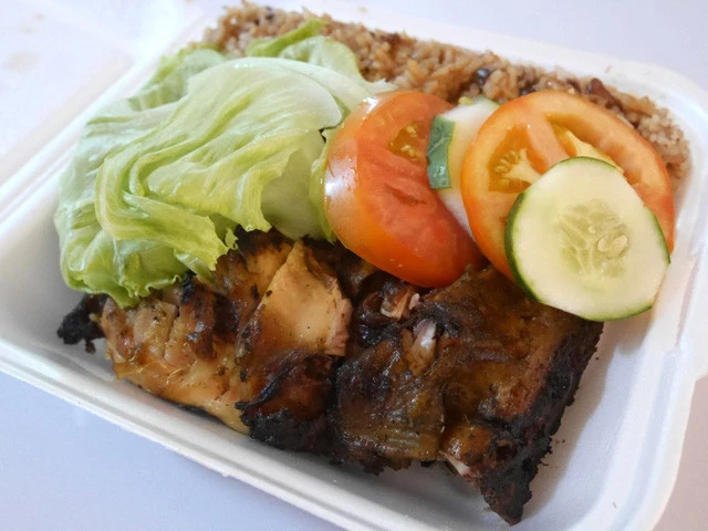 ジャマイカのソウルフード「ジャークチキン」。ライスと生野菜付きのランチボックススタイルが定番