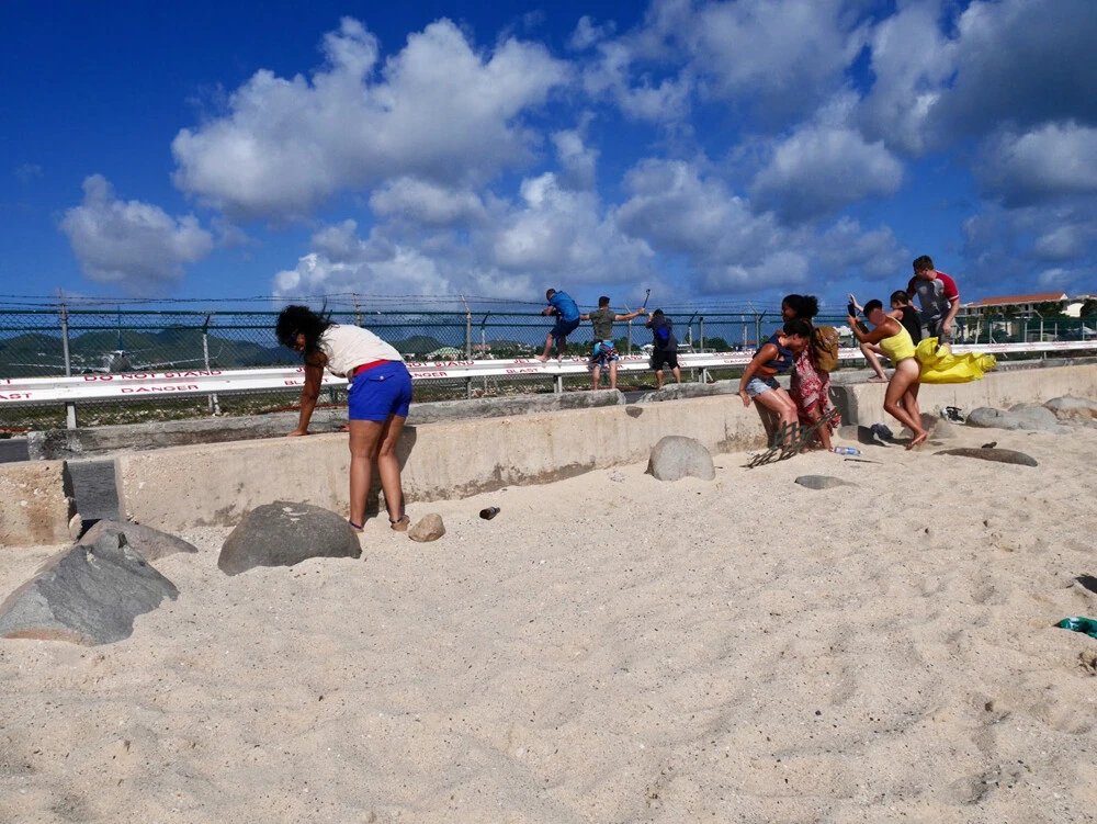 飛行機の強風に耐える人々