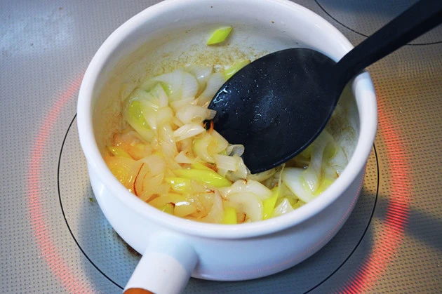 （１）炒める！　鍋に油を引き、細かくカットした長ネギを入れて弱火～中火でしんなりとするまで炒める。次にひと口大にカットしたチャーシューも入れて軽く炒め、水を加えじっくりと煮込む