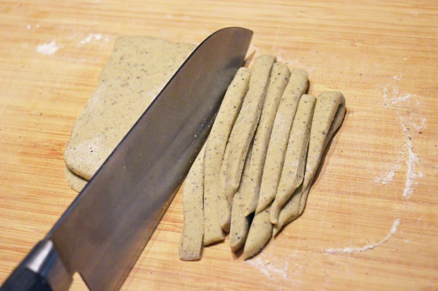 (2)切る! 生地を薄くのばしたら打ち粉をかけ、包丁で細長く切る。なるべく均等の厚さにのばし、均等の太さに切るのがポイント。ゆでたときの固さのムラをなくすことができる
