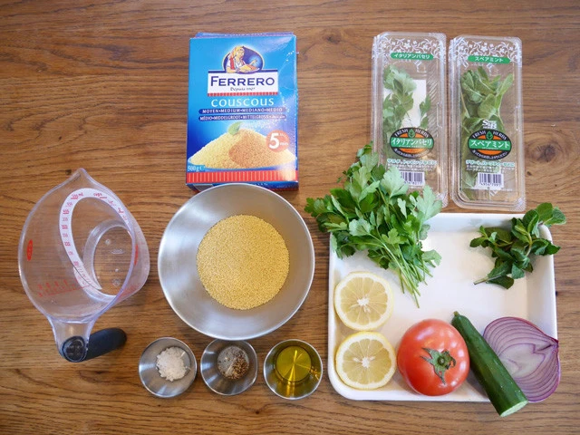 材料。左側：水、クスクス、塩、胡椒、オリーブオイル。バット内：左上からイタリアンパセリ、ミント、レモン、トマト、キュウリ、レッドオニオン