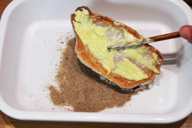 (2)まぶす! (1)の両面にマヨネーズを塗って全体に広げたら、粉末ソースをマヨに付着させるようにまぶす。ソース味はとんかつらしさを感じる重要ポイント。たっぷりと使おう