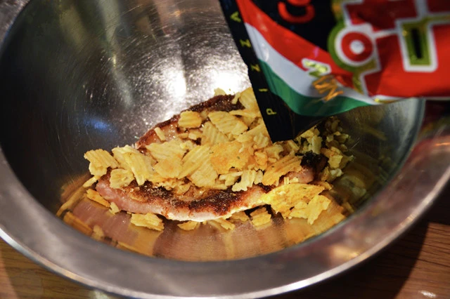 (3)ピザポテ! ピザポテトの袋の上から手でポテトを細かく砕き、(2)の上からたっぷりと振りかければ完成。袋が膨らんで砕きにくい場合は、砕く前に少しだけ袋を開けておくとやりやすい