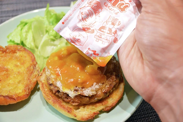 (3)カレー! こんがりと焼き上げたバンズに絶品チーズバーガーのパティをのせたら、アンパンマンミニパックカレーをたっぷりとかけよう。カレーは常温のままかけても問題ない