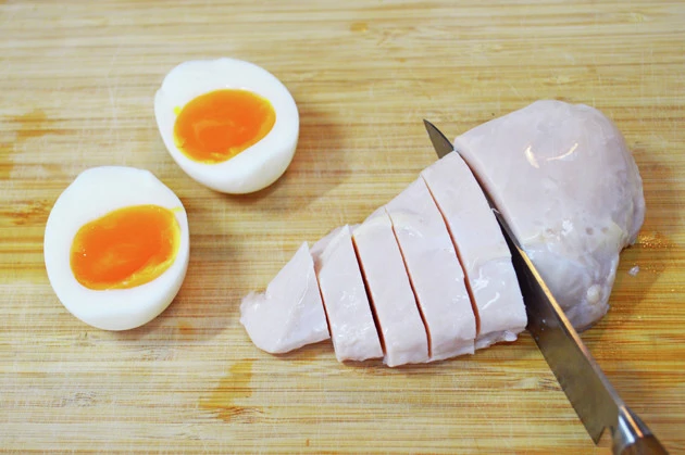 (1)切る! 具材にはタンパク質が豊富なサラダチキンとゆで卵をチョイス。もちろん塩ベースのスープとの相性は抜群だ。麺をゆでる前に食べやすいサイズにカットしておこう