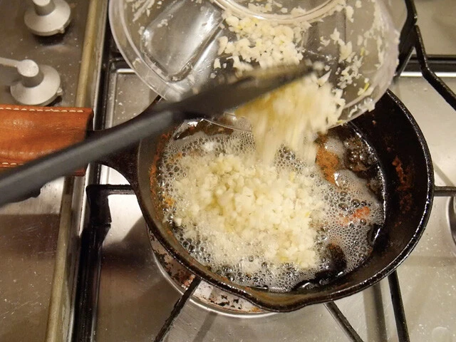 ２．鶏肉を取り出し、残った油でニンニクとコリアンダーパウダー、フェネグリークパウダーを炒める。