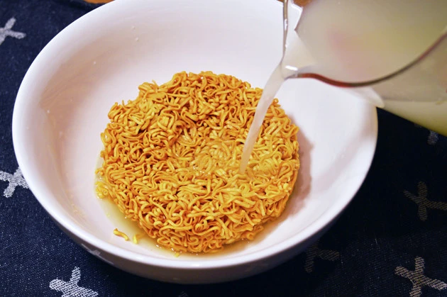 (3)注ぐ! (2)のお湯が白濁し、いいだしが出た頃合いでチキラーを丼に入れ、だしを一度沸騰させたら丼に注ぎフタをする。卵はそのまま入れてもいいがレンチンで温玉にするのがオススメ