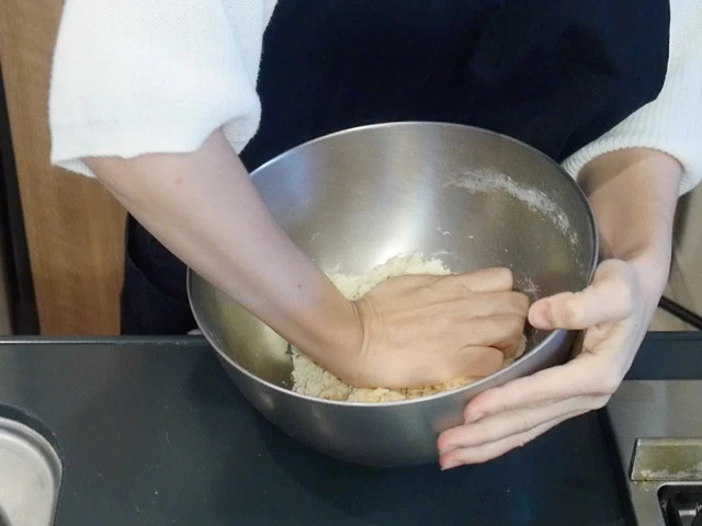 ２．箸で全体を混ぜたら、生地がひとまとまりになるよう手でこねる。