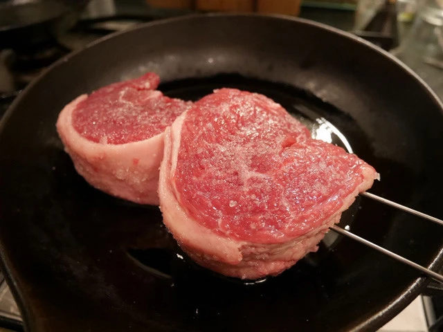 １１．熱したフライパンに油をひき、串に刺さった肉を中弱火でじっくり焼きます。串が邪魔で肉が少しくらい浮いても鍋肌で焼いて熱を伝えればいいのでビビらない。
