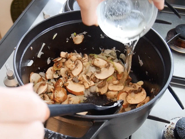 ５．すぐに白ワインを入れアルコールを飛ばすようにして、きのこの旨味を引き出します。