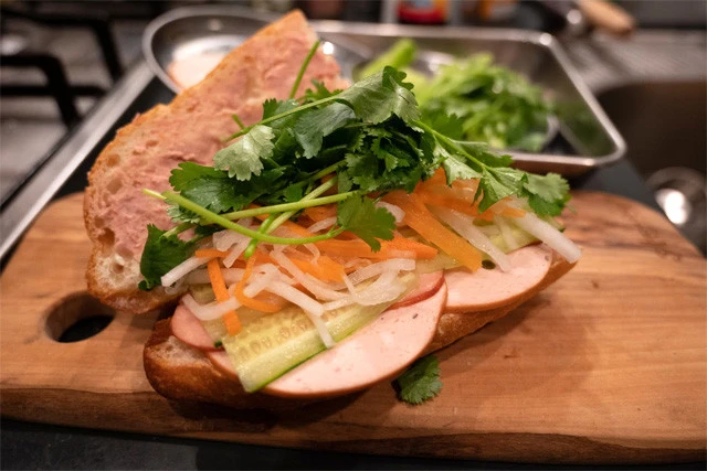 ハム、チャーシュー、キュウリ（薄切り）、なます、パクチーをパンに挟む