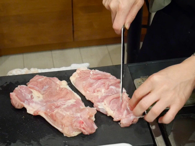 ３．鶏肉の厚い部分が平たくなるように切り開き、味が染み込むように切り込みを入れたり、フォークで穴を開ける。