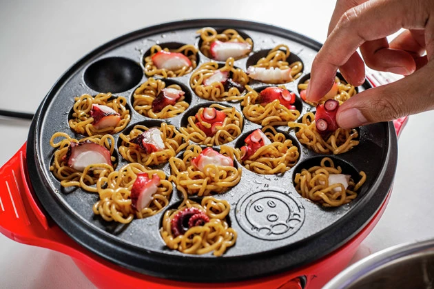 （４）たこ焼き！　たこ焼き器の穴に麺を押し込むようにして生地を入れ、タコと刻み紅しょうがを入れたら通常のたこ焼きよりもじっくりと焼き上げよう。ソースナシでそのままで激ウマ！