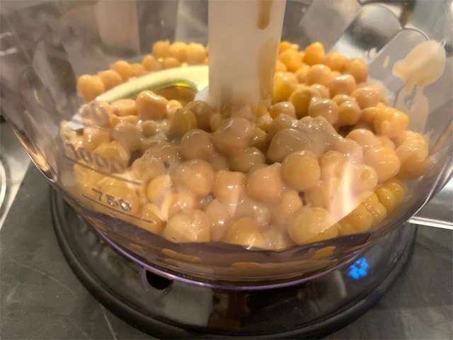 フードプロセッサー（ブレンダー）にひよこ豆、ニンニク、塩、レモン汁を入れて攪拌（かくはん）。