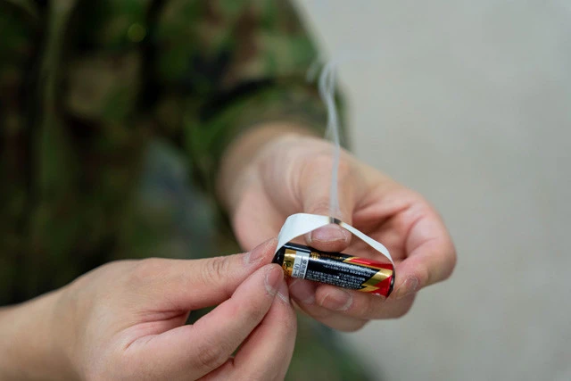 ③電池の両端に銀の面をくっつけると銀紙に電気が通り、中央部分が高熱になり紙の面が着火！　アルミホイルとティッシュなどの紙でも代用できる