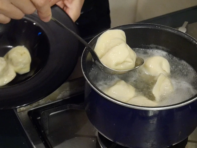 １４．出来上がったペリメニたちを沸騰したお湯で５分ほど茹でる。ペリメニが浮き上がり中まで火が通ったら、水分を切って皿によそう。