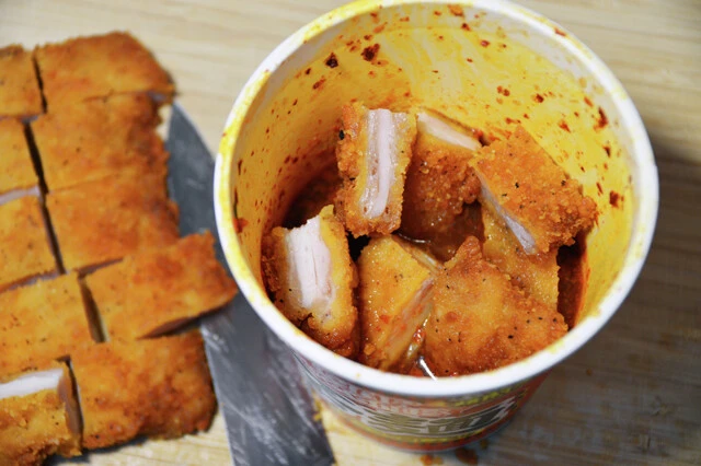 (2)漬ける! ファミチキを包丁でひと口大にカットし、(1)の中に5分程度漬け込む。ファミチキの衣にスープが染み込むほどいい味が出るので、こまめに箸でかき混ぜて全体になじませよう