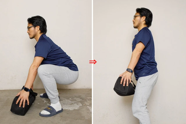 《モノの拾い方・両手で拾う》両手でモノを持ち上げるときも同様に上半身の直線をキープし、お尻を落としてスクワットするように持ち上げる。ぎっくり腰のときでもこの拾い方なら腰への負担が少ない