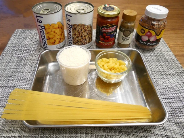 (左上から)ひよこ豆、レンズ豆、トマト(アラビアータ)ソース、クミンパウダー、フライドオニオン、(トレー内)米、マカロニ、スパゲティ