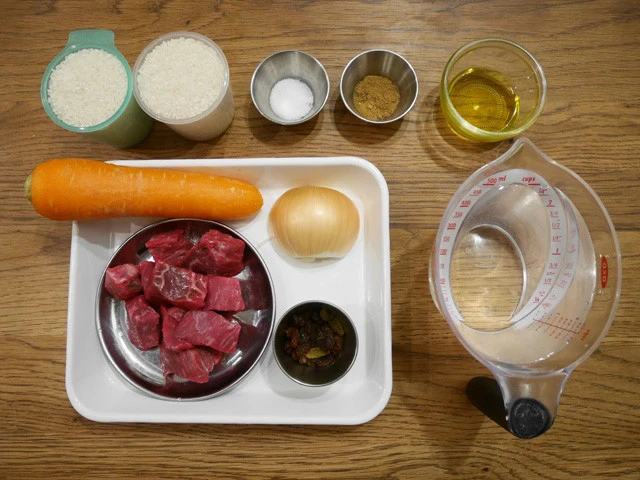(左上から)米、塩、クミン、油、水、(バッドの中)にんじん、玉ねぎ、レーズン、牛肉