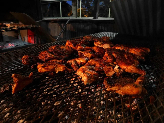 炭火で焼かれるジャークチキン。ワイルドに焦げ焼けたチキンが美味しそう!