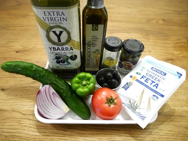 (上段左から)オリーブオイル、白ワインビネガー、オレガノ、ケッパー、(下段左から)赤玉ねぎ、キュウリ、ピーマン、トマト、オリーブ、フェタチーズ