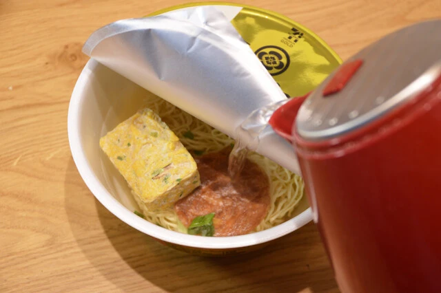 らぁ麺飯田商店 しょうゆらぁ麺にかきたまスープを加えて熱湯を入れ、金の黒酢酢豚をかける。マイルドな酸味の高級ラーメンの完成!