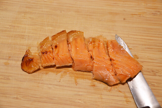 金の鮭ハラミ西京焼をスライスし、鮭おにぎりにのせてラップで強引に一体化。しっとりと鮭の脂が染み込んだ白米が最強すぎ！