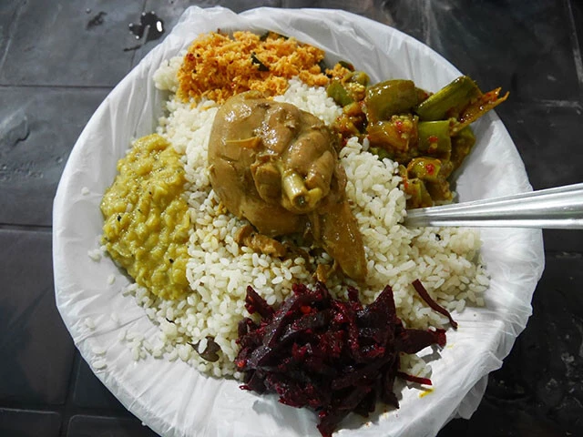 チキンカレーや豆カレー、ビーツのカレー、ポルサンボル（ココナッツのふりかけ）などが盛られたライスアンドカリー
