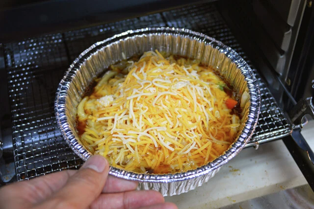 (2)焼く! (1)の上から表面を覆い隠すようにチーズをたっぷりとのせ、トースターでじっくりと焼く。チーズが溶けて表面にカリカリの焦げ目がつき、つゆがグツグツと煮立てば完成