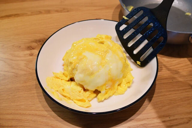 (3)のせる! 卵は全体を軽くかき混ぜながらじっくり焼くことがポイント。ふわとろに焼き上がったらアツアツのうちに(1)の上からのせる。見た目も意識して、映えるように盛りつけよう