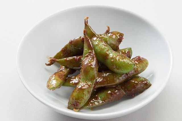 無限えだまめ【冷凍枝豆】①冷凍枝豆を袋の表示どおりレンジで加熱する②熱いうちに、皮ごととんこつ辛味噌を加えて混ぜ合わせる