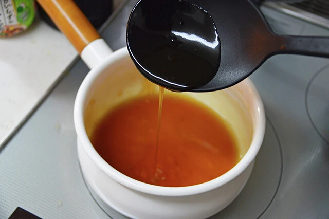 (2)とろみ! めんつゆを希釈して鍋に入れて加熱し、温まったら火を止めて水溶き片栗粉を入れて再加熱。全体にとろみがついたら再度火を止めカニカマスティックをどっぷりとディップする